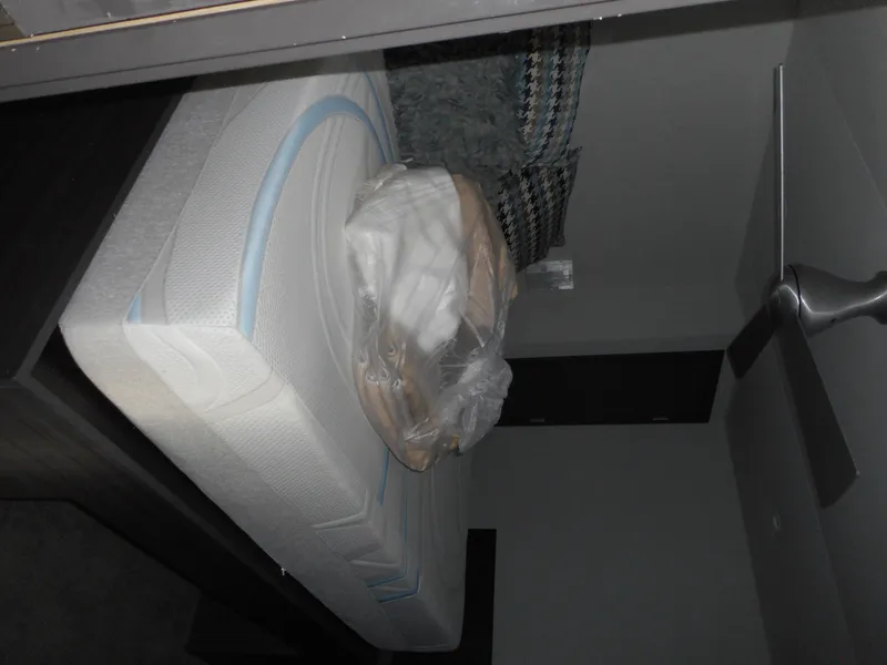 Slide: The Image of A bed with a mattress and pillows in a modern room, featuring a ceiling fan. - 5