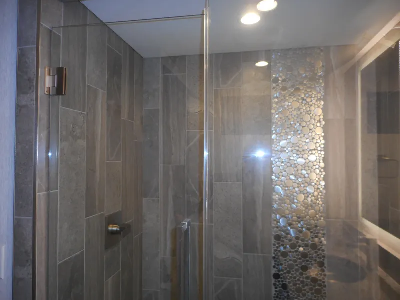 Slide: The Image of Modern shower with gray tiles and pebble accent, featuring Adonia Liquidity Trip 5 design. - 9