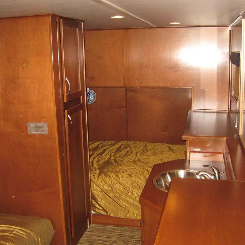Slide: The Image of 2010 Bravada Houseboat Dream Catcher interior with wood finish and compact sink. - 7