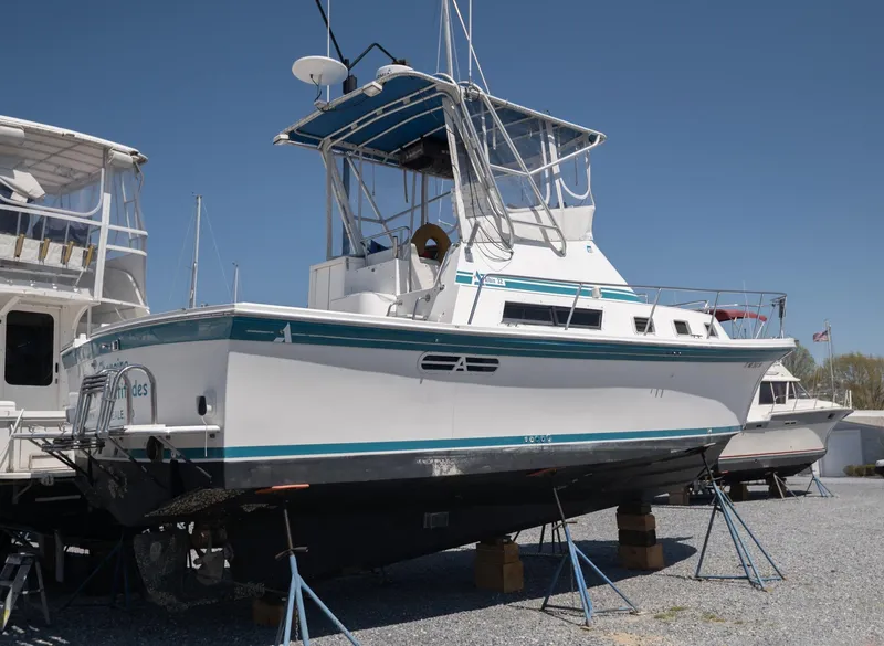 Slide: The Image of 1996 Albin 32 Command Bridge boat on stands, displayed outdoors under clear blue sky. - 1