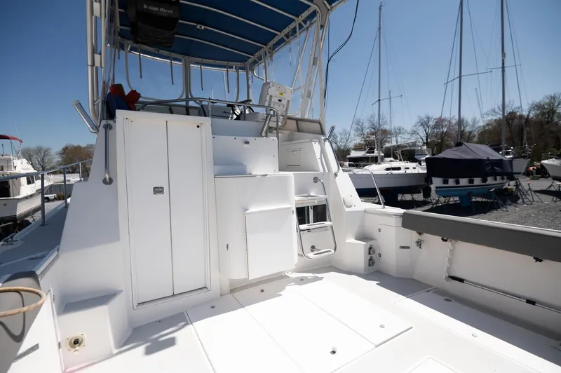 Slide: The Image of 1996 Albin 32 Command Bridge boat deck with seating and helm, docked in a marina. - 14