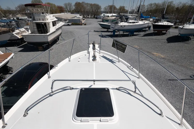 Slide: The Image of 1996 Albin 32 Command Bridge boat on gravel lot with other vessels. - 25