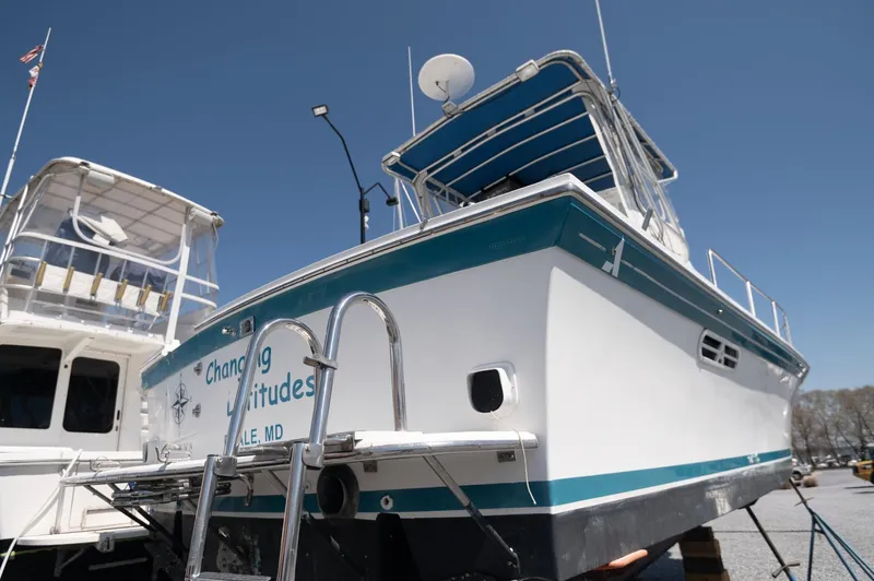 Slide: The Image of 1996 Albin 32 Command Bridge boat with ladder, docked under clear blue sky. - 27