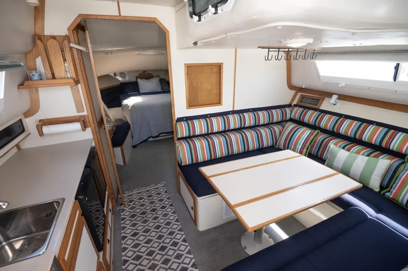Slide: The Image of Interior of 1996 Albin 32 Command Bridge with striped seating and compact kitchen area. - 4