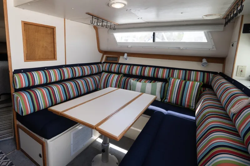 Slide: The Image of 1996 Albin 32 Command Bridge interior with striped seating and dining table. - 5