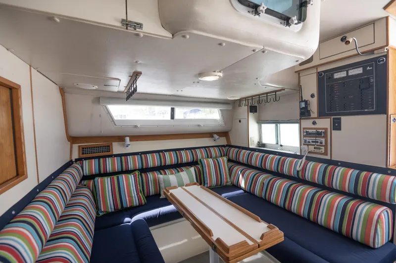 Slide: The Image of Interior of 1996 Albin 32 Command Bridge with striped seating and wooden table. - 6