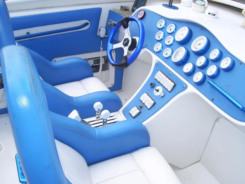 Slide: The Image of 2002 Mares 38 High Performance boat interior with blue and white seating and dashboard. - 11