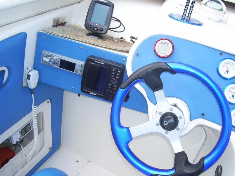Slide: The Image of Steering wheel and dashboard of a 2002 Mares 38 High Performance boat with navigation equipment. - 13