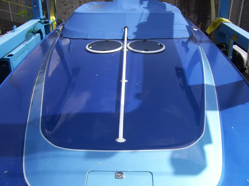 Slide: The Image of 2002 Mares 38 High Performance boat with blue cover, docked and ready for use. - 2