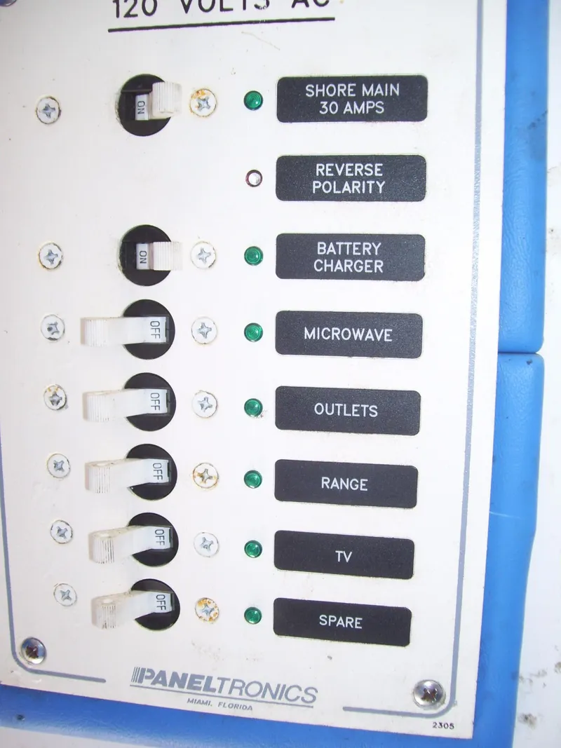 Slide: The Image of Electrical panel with labeled switches for shore main, battery charger, microwave, outlets, and more. - 20