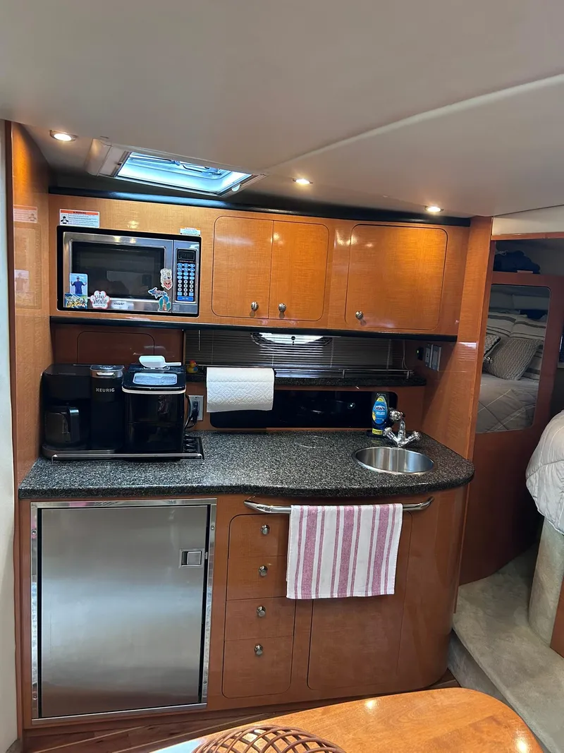 Slide: The Image of 2007 Chaparral 350 Signature yacht interior kitchen with appliances and wooden cabinetry. - 25