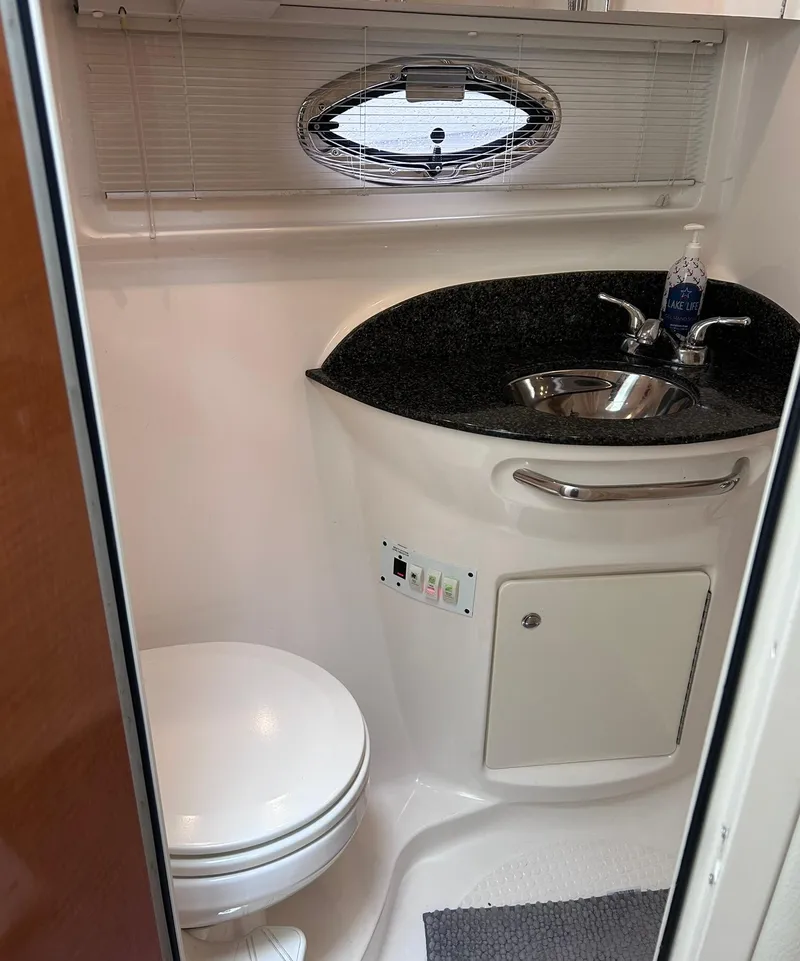 Slide: The Image of 2007 Chaparral 350 Signature boat bathroom with sink, toilet, and oval window. - 27