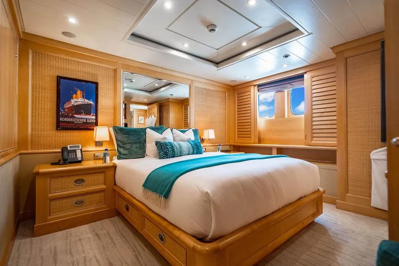 Slide: The Image of Luxurious 2004 Amels Oceangoing yacht bedroom with elegant wood paneling and plush bedding. - 13