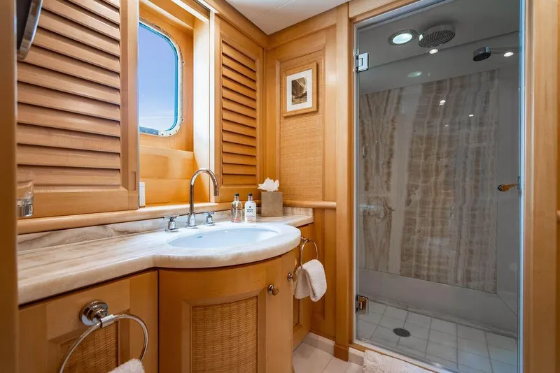 Slide: The Image of Luxurious yacht bathroom with wooden cabinetry, marble sink, and glass shower, Amels Oceangoing 2004. - 14