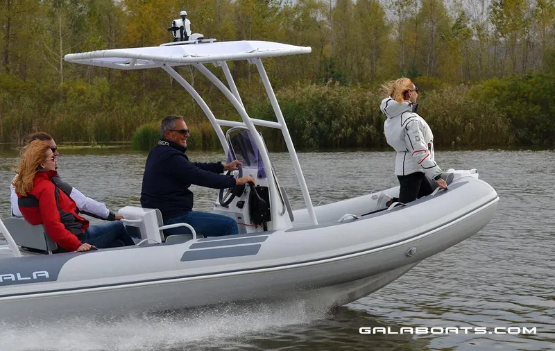 Slide: The Image of People enjoying a ride on a 2024 Gala VIKING V500 boat on a calm river. - 11
