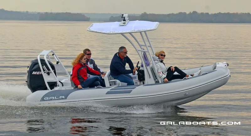 Slide: The Image of 2024 Gala VIKING V500 boat cruising on a calm lake with four passengers. - 9