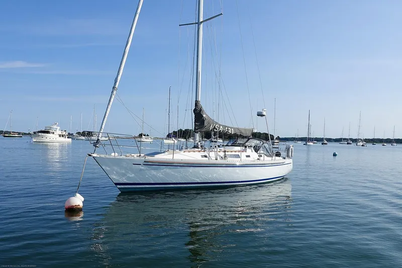 Slide: The Image of 1989 Nordic 40 sailboat anchored in calm waters under a clear blue sky. - 0