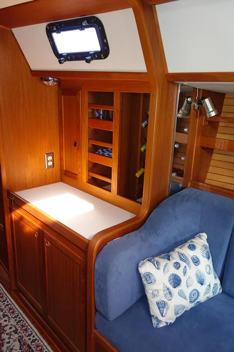 Slide: The Image of Cozy Nordic 40 yacht interior, 1989 model, featuring wooden cabinetry and blue cushioned seating. - 100