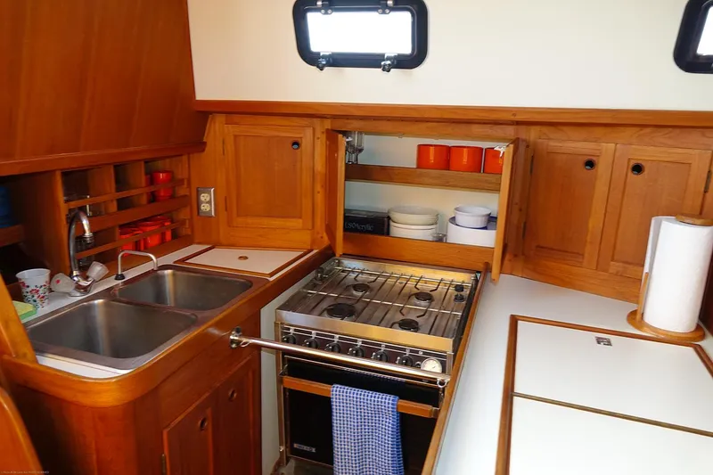 Slide: The Image of Cozy Nordic 40 sailboat kitchen with wooden cabinets, dual sink, and stove, built in 1989. - 24