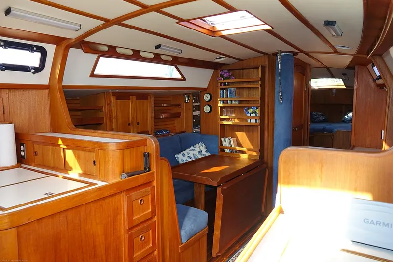 Slide: The Image of Interior of a 1989 Nordic 40 sailboat with wooden cabinetry and blue seating. - 26