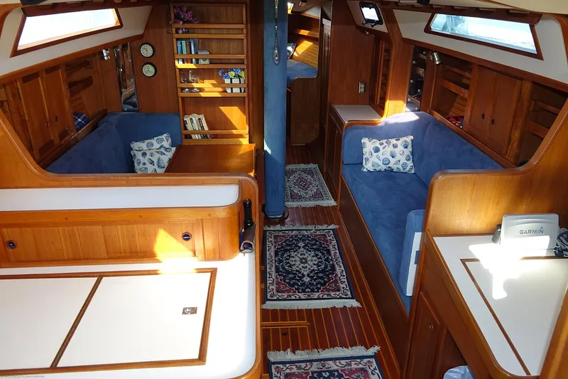 Slide: The Image of Interior of a 1989 Nordic 40 sailboat with wooden furnishings and blue seating. - 27