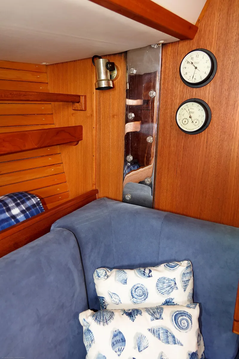 Slide: The Image of Cozy Nordic 40 yacht interior with blue cushions, nautical pillows, and wooden paneling, built in 1989. - 29
