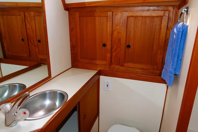 Slide: The Image of Wooden bathroom vanity with sink, mirror, and blue towel in a 1989 Nordic 40 boat. - 37
