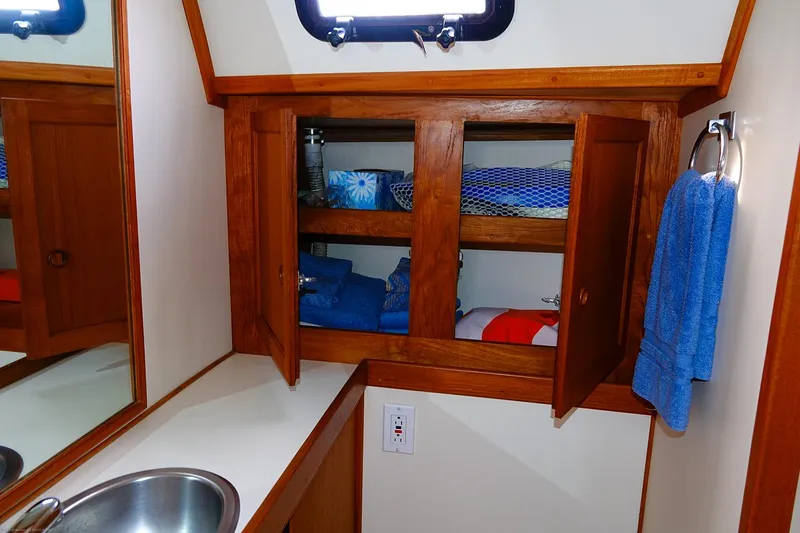 Slide: The Image of 1989 Nordic 40 bathroom with wooden cabinets, blue towels, and stainless steel sink. - 38