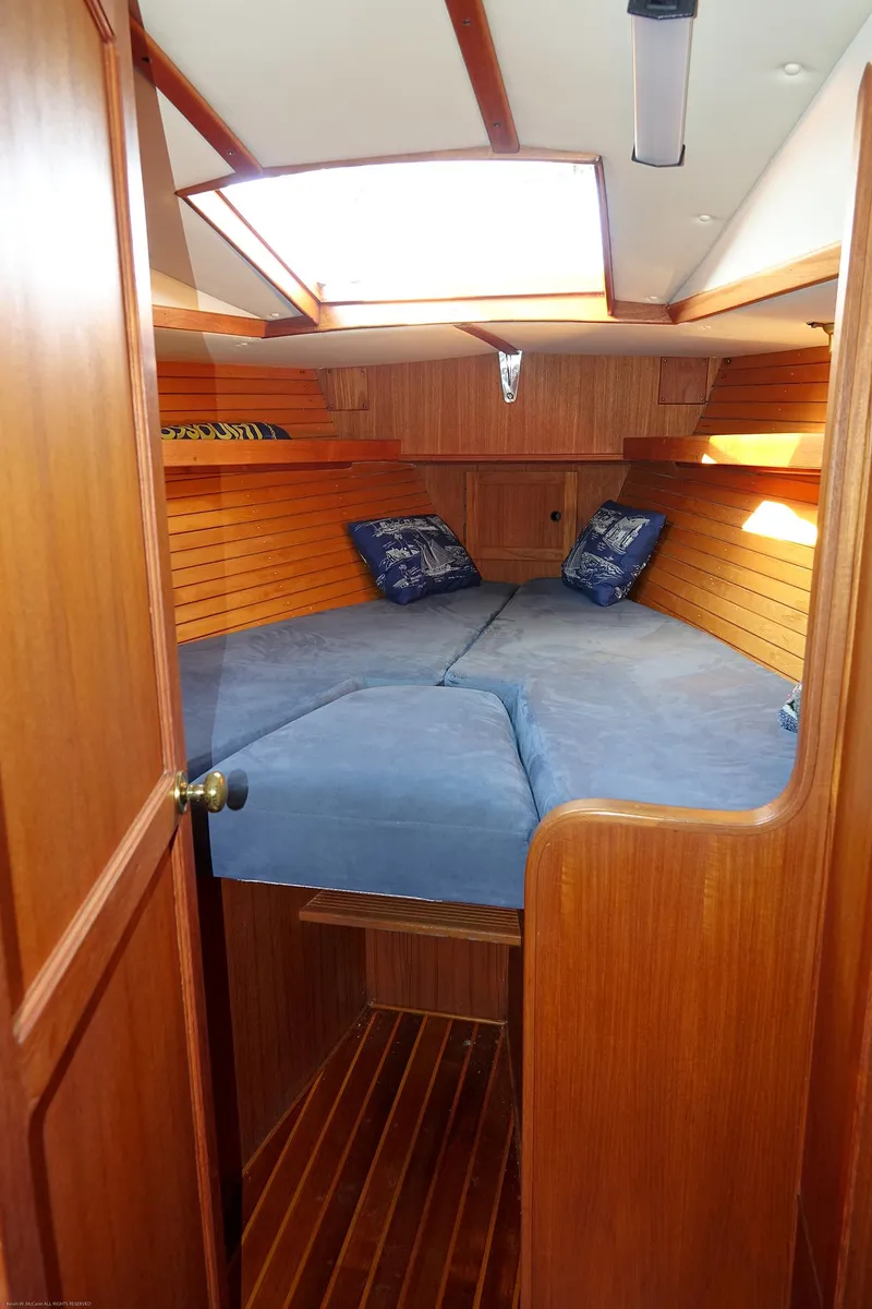 Slide: The Image of Cozy cabin interior of 1989 Nordic 40 sailboat with wooden finish and blue bedding. - 40