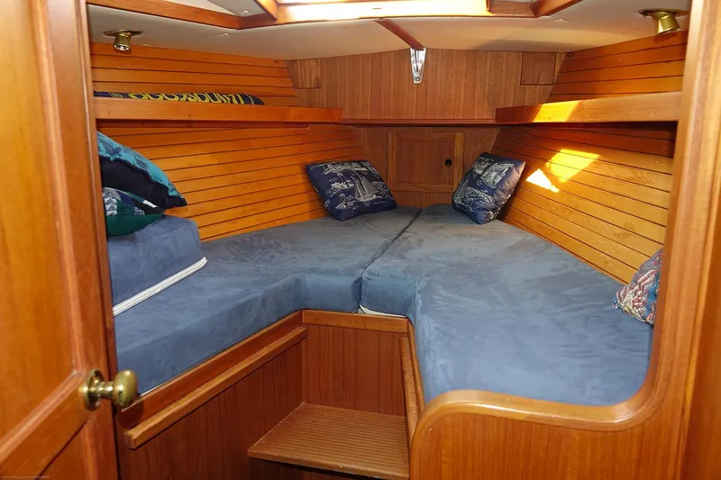 Slide: The Image of Cozy cabin interior of 1989 Nordic 40 sailboat with blue cushions and wooden paneling. - 41