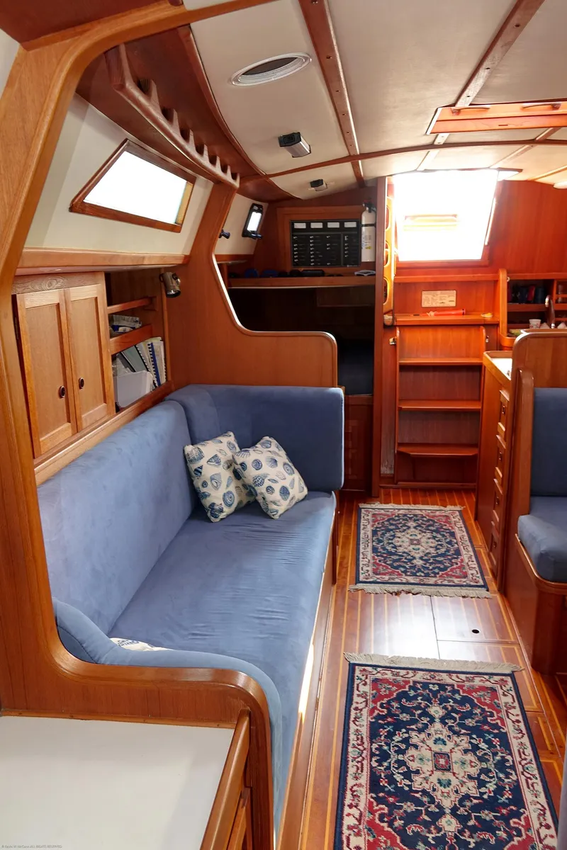 Slide: The Image of Interior of 1989 Nordic 40 sailboat with wooden finish and blue seating. - 43