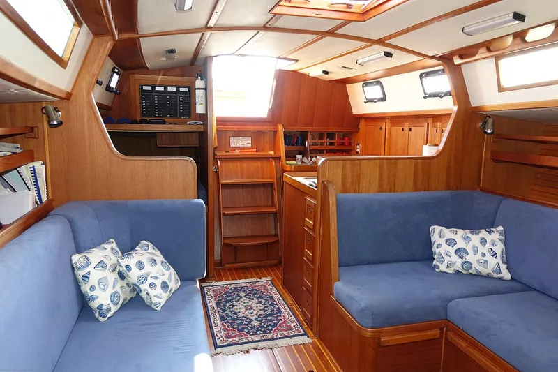 Slide: The Image of Interior of 1989 Nordic 40 sailboat with blue seating and wooden finishes. - 45