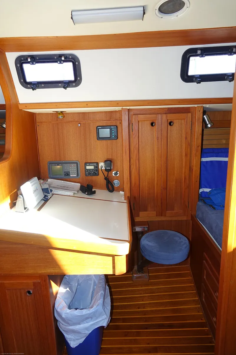 Slide: The Image of 1989 Nordic 40 sailboat interior with navigation station, wooden cabinetry, and cozy seating. - 46