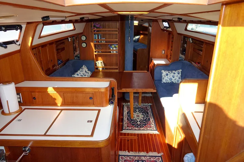Slide: The Image of Interior of 1989 Nordic 40 sailboat with wooden furnishings and blue seating. - 49