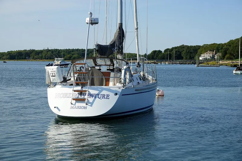 Slide: The Image of Sailboat Nordic 40 (1989) anchored in calm waters, surrounded by scenic greenery. - 6