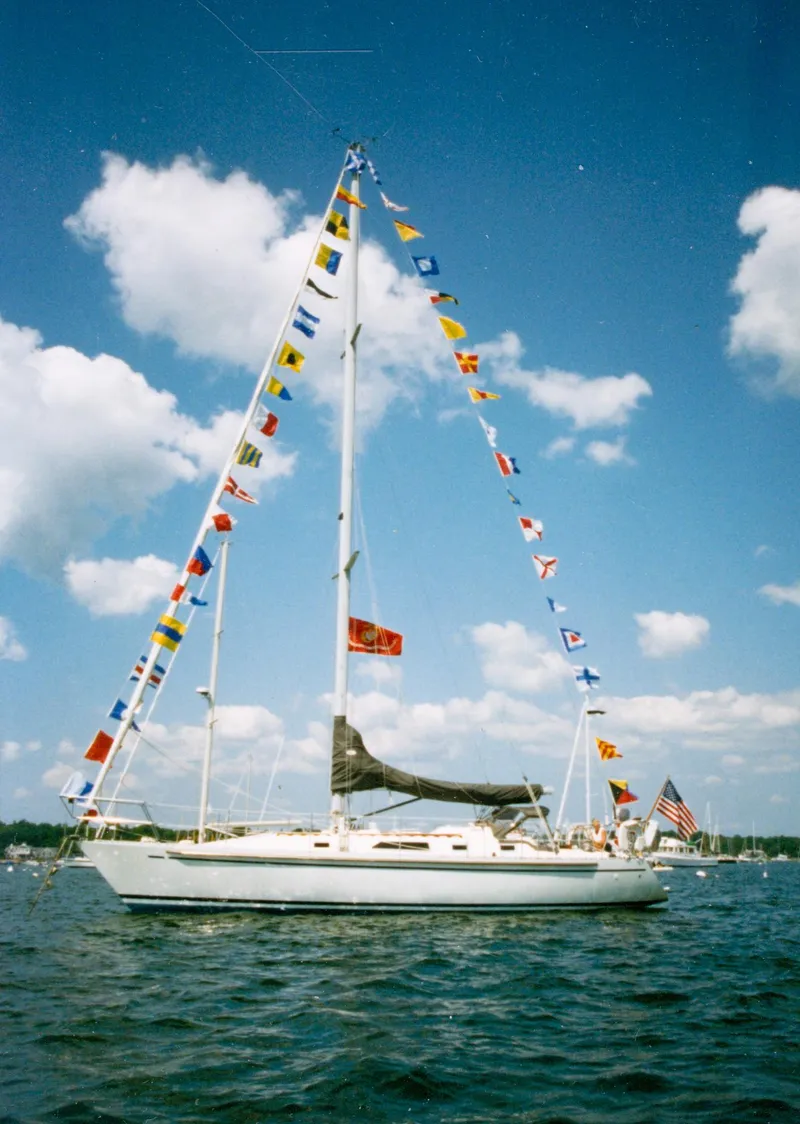 Slide: The Image of Sailboat Nordic 40 (1989) with colorful flags on a sunny day at sea. - 7