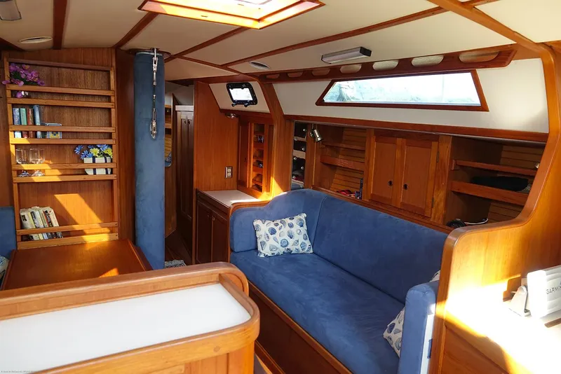 Slide: The Image of Interior of a 1989 Nordic 40 sailboat with wooden furnishings and blue upholstery. - 98