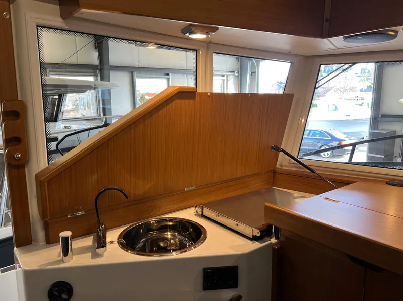 Slide: The Image of Interior of 2024 Sargo 28 boat featuring a compact kitchen area with sink and stove. - 14