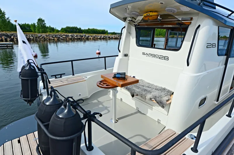 Slide: The Image of 2024 Sargo 28 boat with outdoor seating and table on calm water. - 32