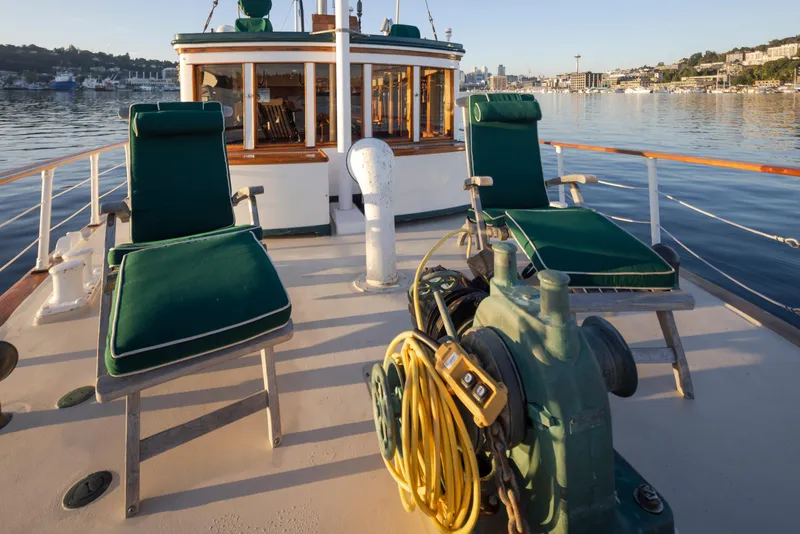 Slide: The Image of Deck of a 1931 Boeing Custom boat with green lounge chairs and waterfront view. - 20