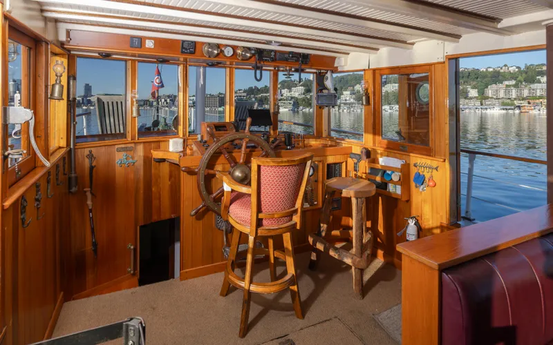 Slide: The Image of Vintage 1931 Boeing Custom boat interior with wooden helm and scenic waterfront view. - 32