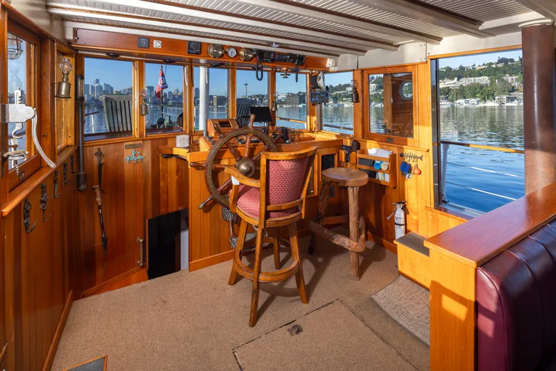 Slide: The Image of Vintage 1931 Boeing Custom boat interior with wooden helm and scenic water view. - 36