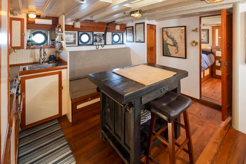 Slide: The Image of Cozy 1931 Boeing custom boat interior with wooden decor, kitchenette, and seating area. - 48