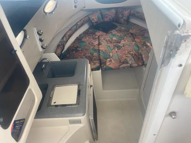 Slide: The Image of 1996 Pro-Line 2950 Mid Cabin interior with kitchenette and cozy sleeping area. - 2