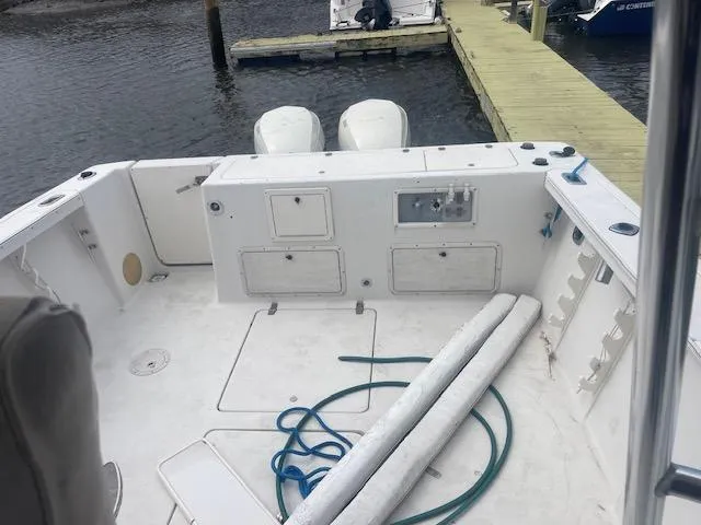 Slide: The Image of 1996 Pro-Line 2950 Mid Cabin boat deck with storage compartments and dock view. - 8