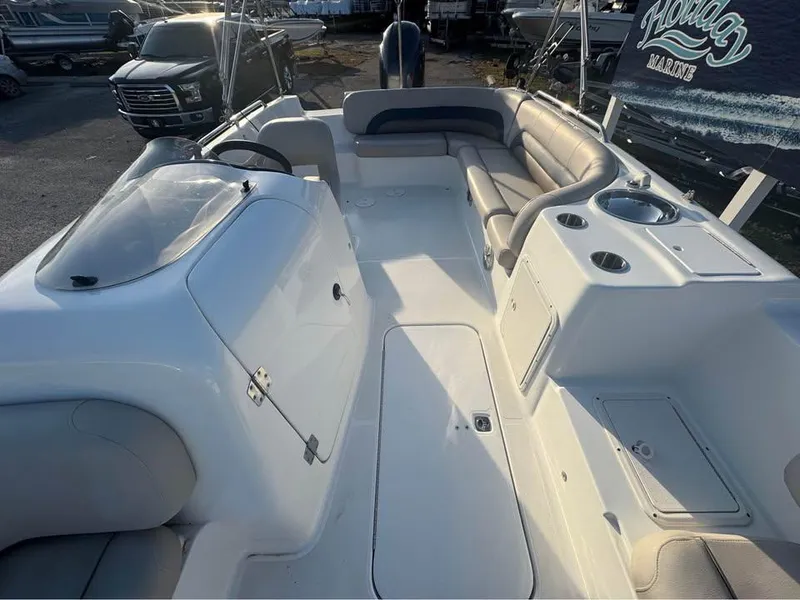 Slide: The Image of 2018 Hurricane SS 232 boat interior with seating and helm, parked outdoors. - 5