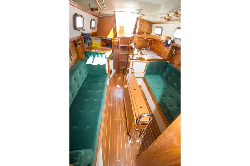 Slide: The Image of Interior of 1992 Pacific Seacraft 34 sailboat with green seating and wooden finishes. - 10