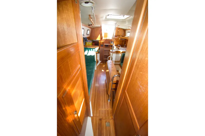 Slide: The Image of Interior of 1992 Pacific Seacraft 34 sailboat with wooden finishes and green seating. - 11