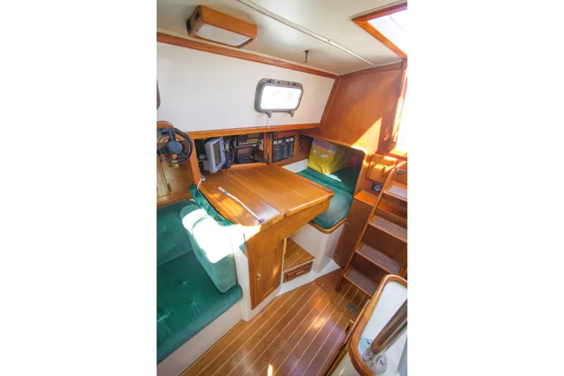 Slide: The Image of Interior of 1992 Pacific Seacraft 34 sailboat with wooden table and green seating. - 15
