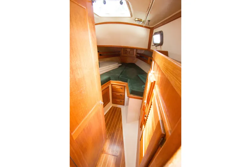 Slide: The Image of Cozy cabin interior of 1992 Pacific Seacraft 34 sailboat with wooden finish and green cushions. - 17